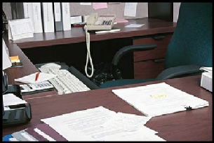 Office worker booth with files, corded phone, desks and typical stationary tools with PC keyboard in the view