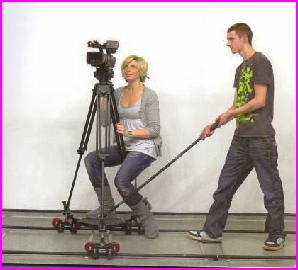 typical movie crew action with camera and dolly and two members of the crew